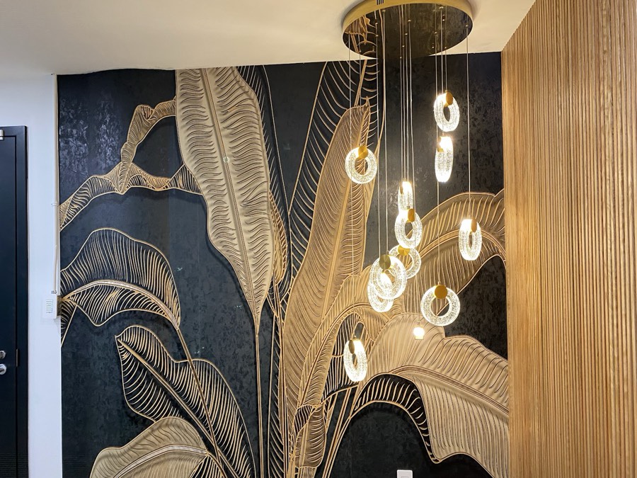 Feature wall with a botanical mural and a sculptural pendant light