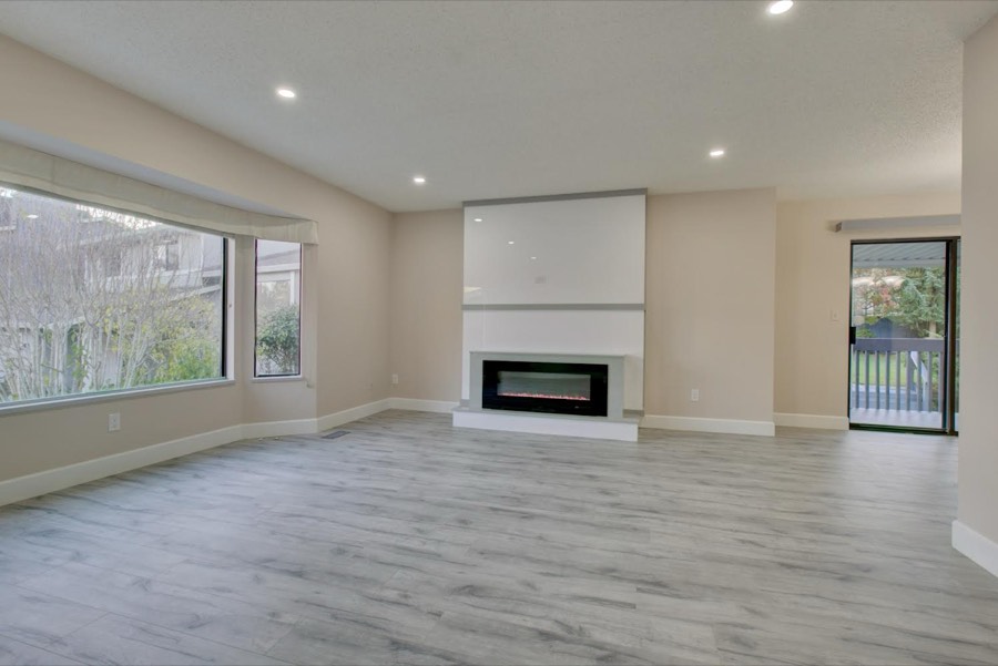 Open living room with a linear fireplace and pot lighting